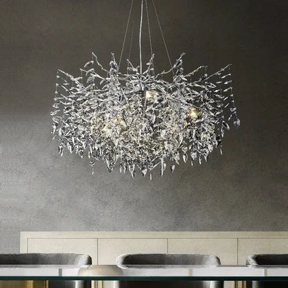 A modern silver and black decorbites crystal pendant chandelier with intricate leaf like branch design for dining room decor