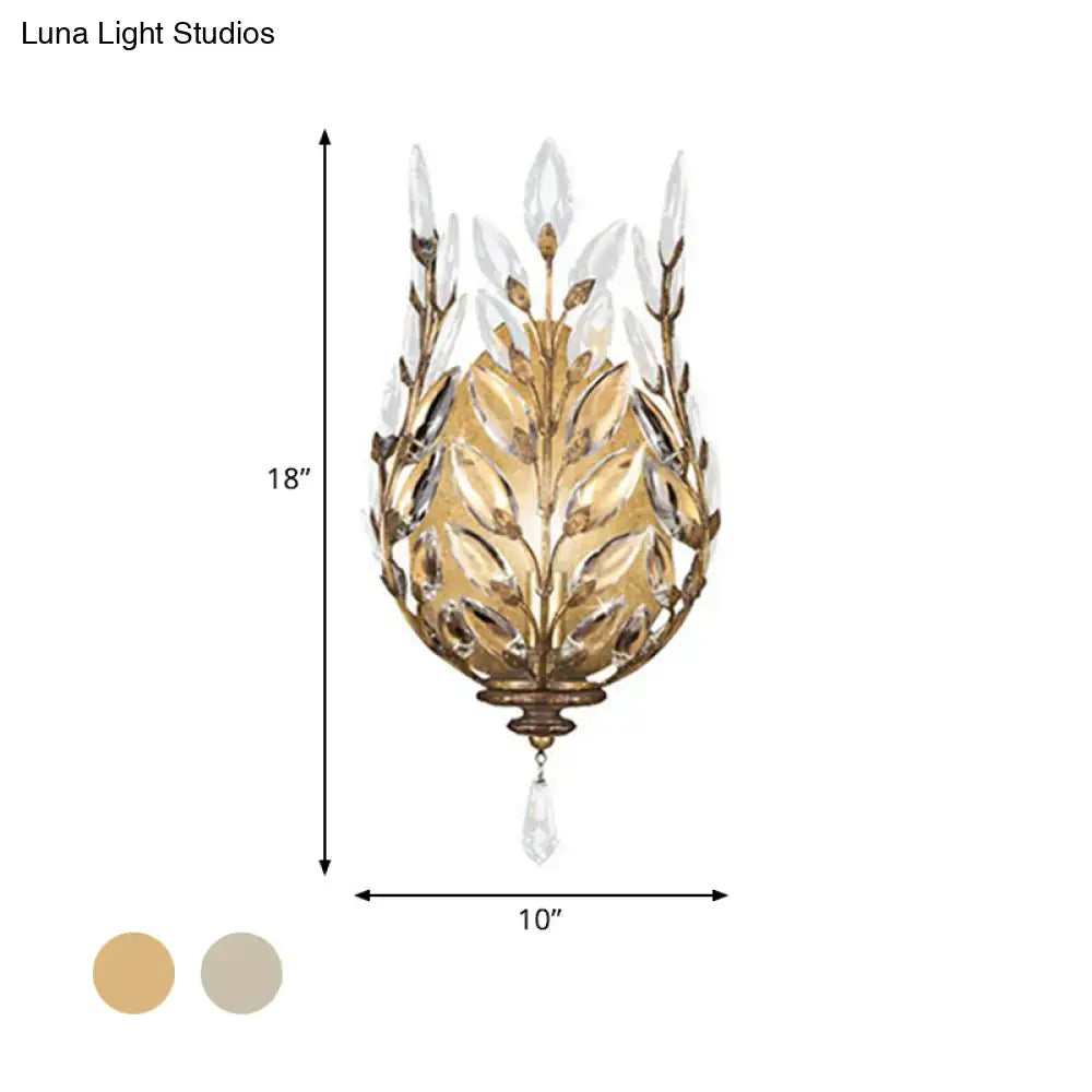 Modern silver brass wall light with gold-toned laurel design and crystal drop for elegant bedroom decor
