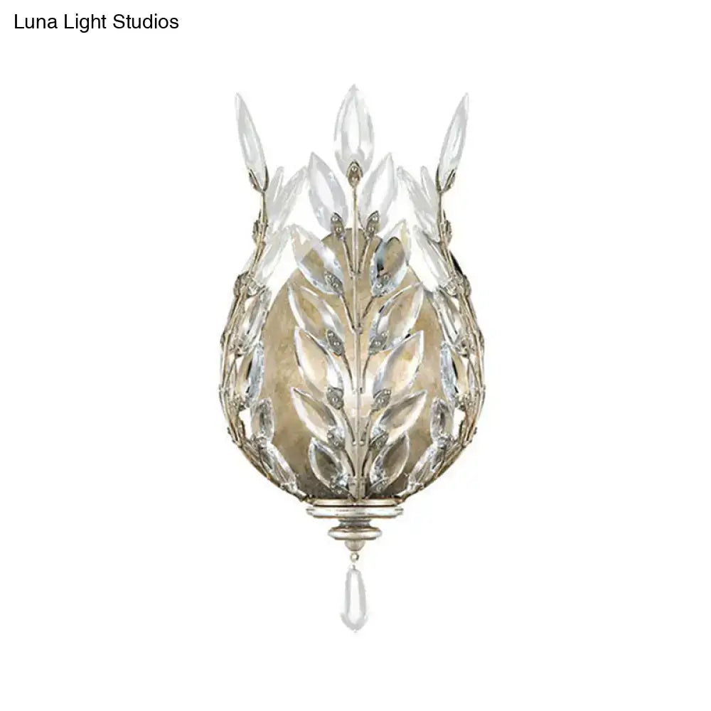 Elegant silver and brass wall light with leafy crystal drop design and clear glass accents for bedroom decor