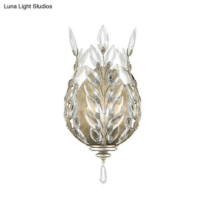 Elegant silver and brass wall light with leafy crystal drop design and clear glass accents for bedroom decor