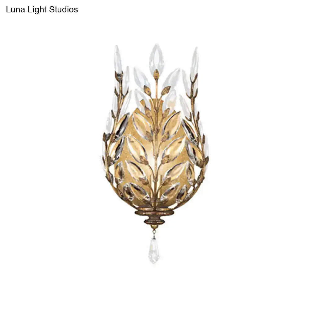 Gold-toned wall light with silver brass laurel design and crystal drop featuring intricate leaf and teardrop pendant details