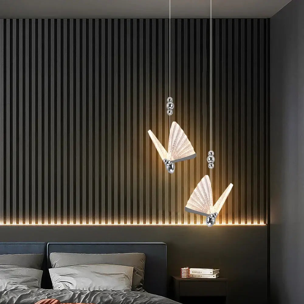 Two modern silver decorbites butterfly led pendant lights with metallic bodies and translucent wings for living room decor