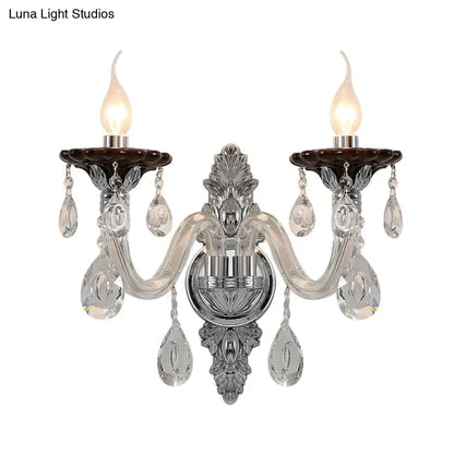 Elegant silver candle wall mounted sconce with chrome and crystal two-light design and dark brown ceramic holders