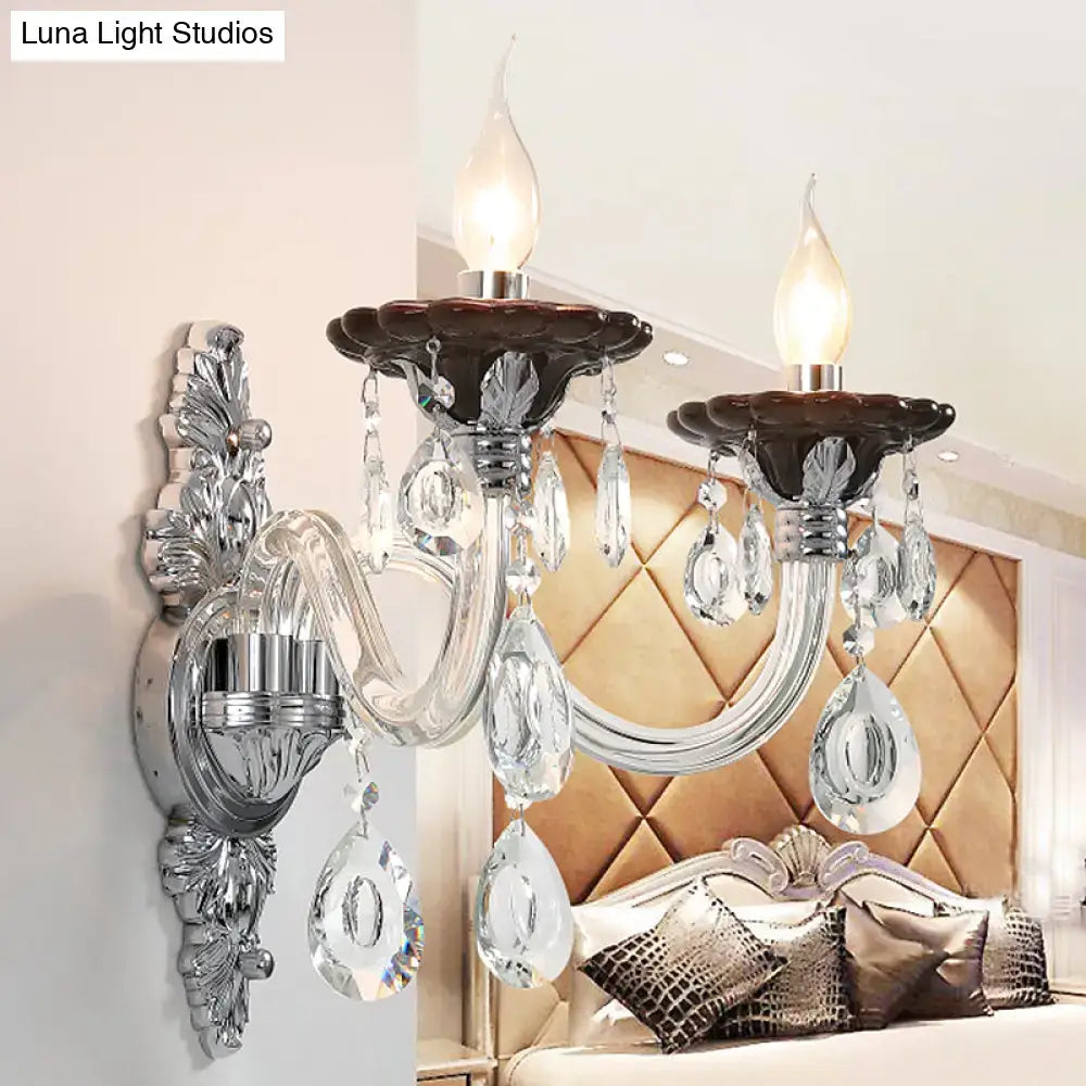 Modern silver candle wall mounted sconce with chrome finish, candle bulbs, crystal pendants, and ornate leafy detailing
