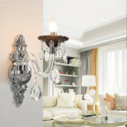 Modern silver candle wall mounted sconce with chrome finish dark brown ceramic base and dangling crystal droplets