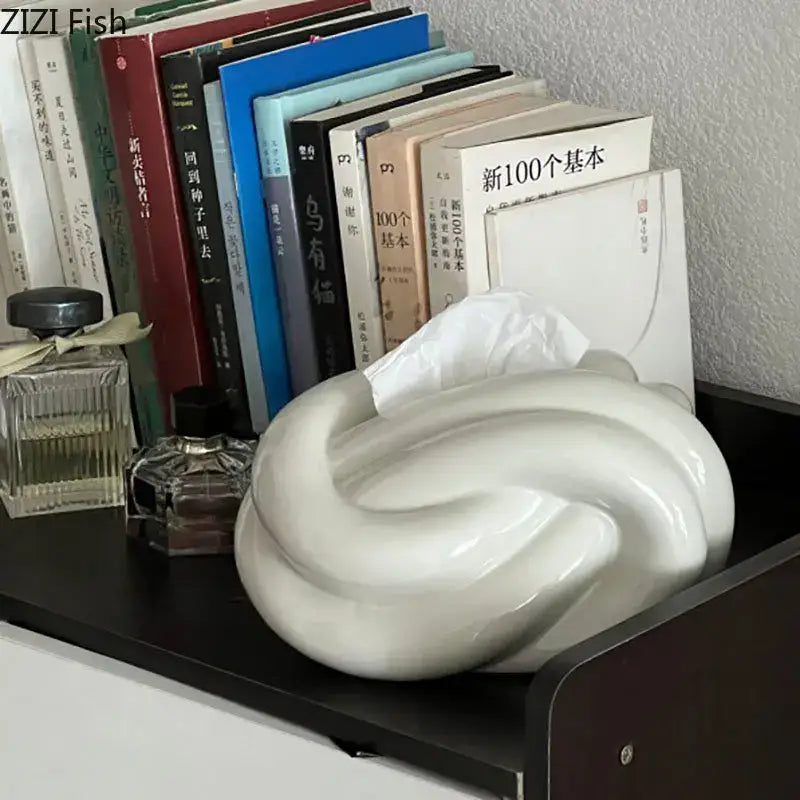 A sleek glossy white ceramic knot tissue box with a modern swirling design for living room decorbites decor