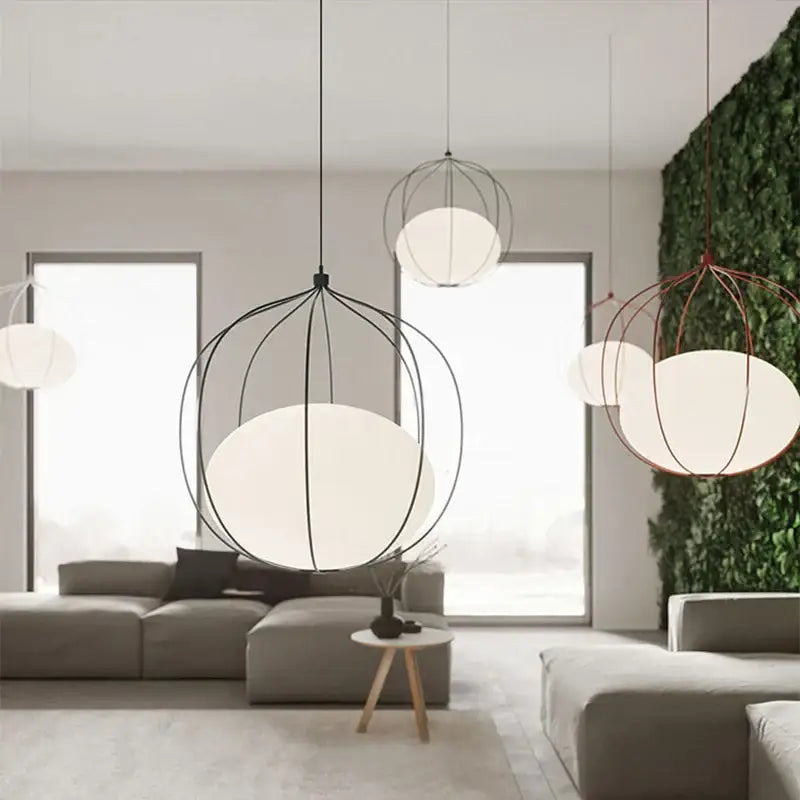 Modern silver and copper birdcage glass ball pendant light featuring black and copper wire frames with white diffusers hanging in dining room