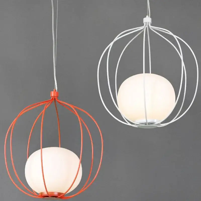 Two spherical glass ball pendant lights with orange and white birdcage frames for modern dining room lighting
