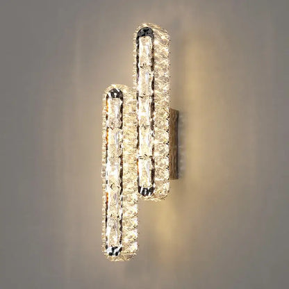 Modern silver crystal led wall lamp featuring two vertical staggered bars of clear faceted crystals in sleek frame