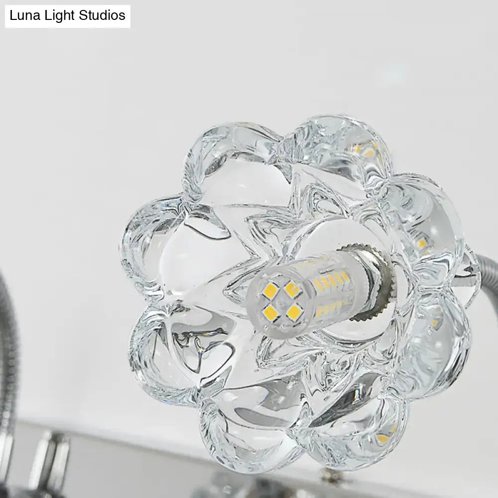 Modern silver crystal petal gooseneck arm vanity light with clear glass flower-shaped fixture and visible led bulb center