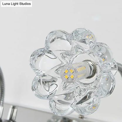 Modern silver crystal petal gooseneck arm vanity light with clear glass flower-shaped fixture and visible led bulb center