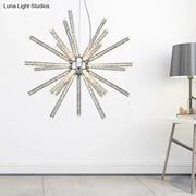 Silver starburst chandelier pendant with clear crystal rods radiating from a central chrome fixture for hanging ceiling use