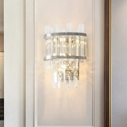Modern silver crystal tiered wall mounted wall light with sleek metal frame and cascading faceted crystals emitting warm light