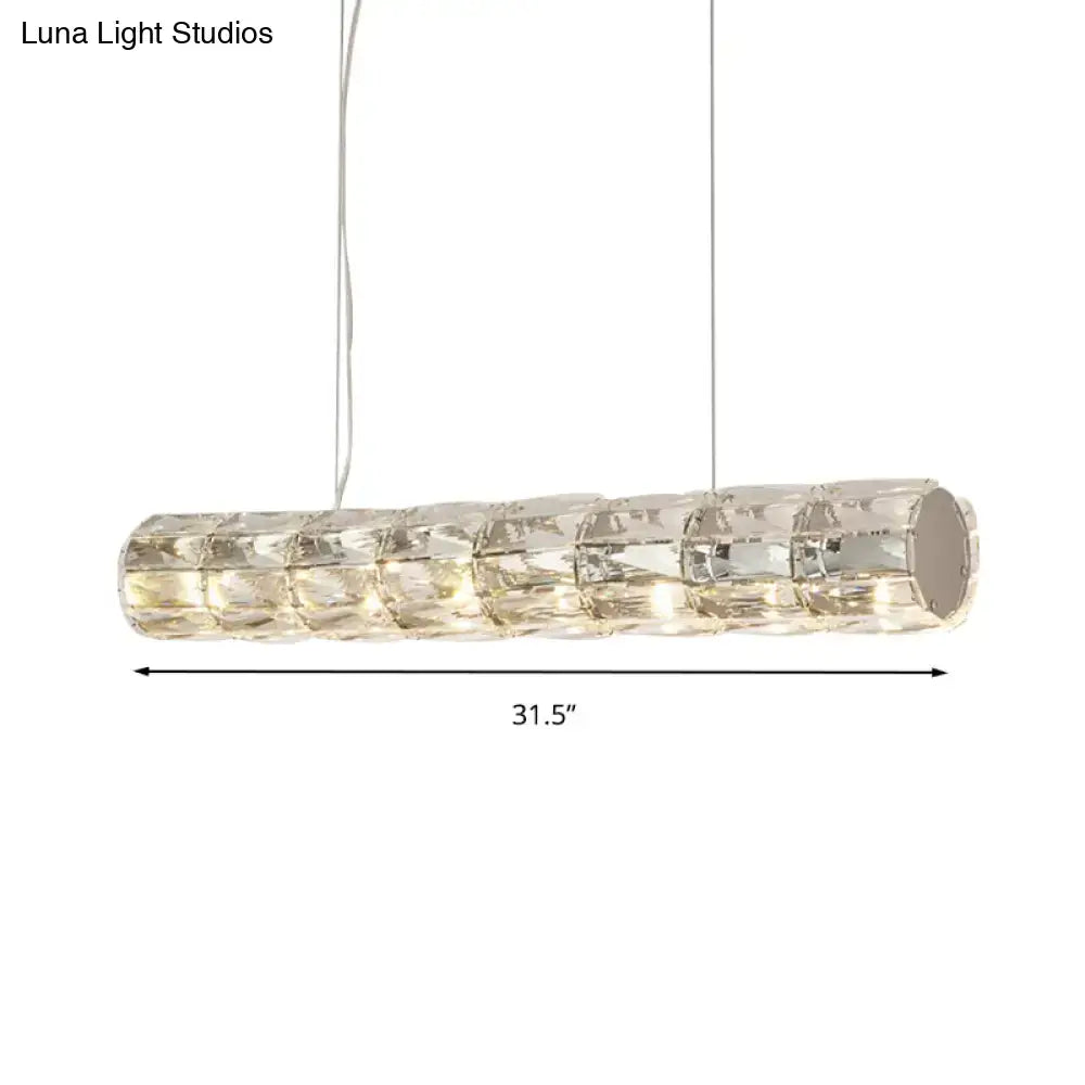 Modern silver crystal tube island light with segmented crystal panels refracting warm white led light for dining rooms