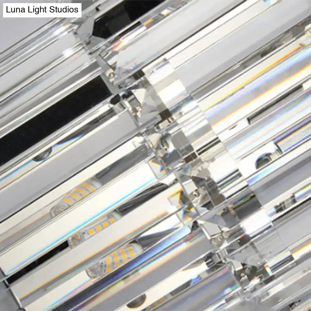 Modern silver crystal wall mounted light with sleek geometric design and clear prisms refracting vibrant rainbow hues