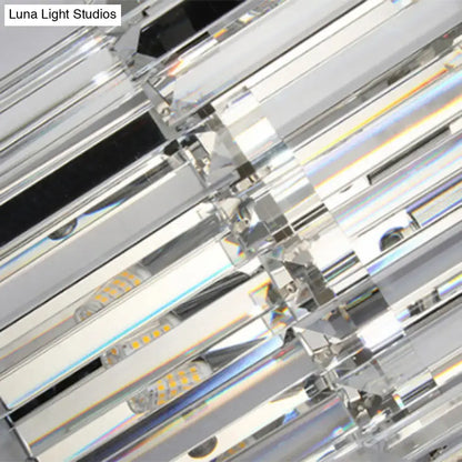 Modern silver crystal wall mounted light with sleek geometric design and clear prisms refracting vibrant rainbow hues