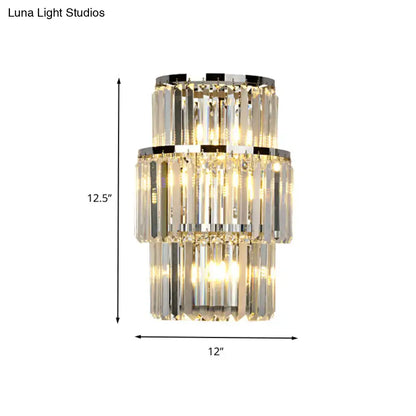 Modern silver crystal wall mounted light featuring a three-tiered crystal chandelier with chrome mounted light accents