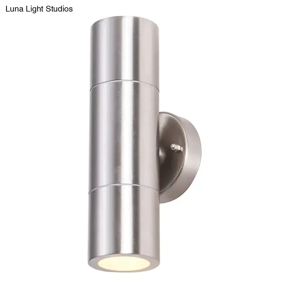 Modern silver cylindrical stainless steel dual-head outdoor wall sconce with a brushed finish and minimalist design