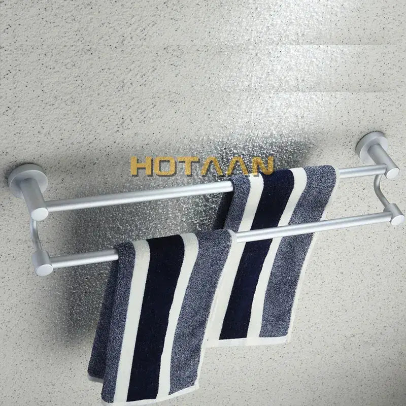 Modern silver double towel bar made of metal holding navy and white striped towels for bathroom use