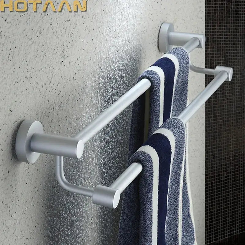 Modern silver double towel bar with sleek design holding navy and white striped towels for bathroom use