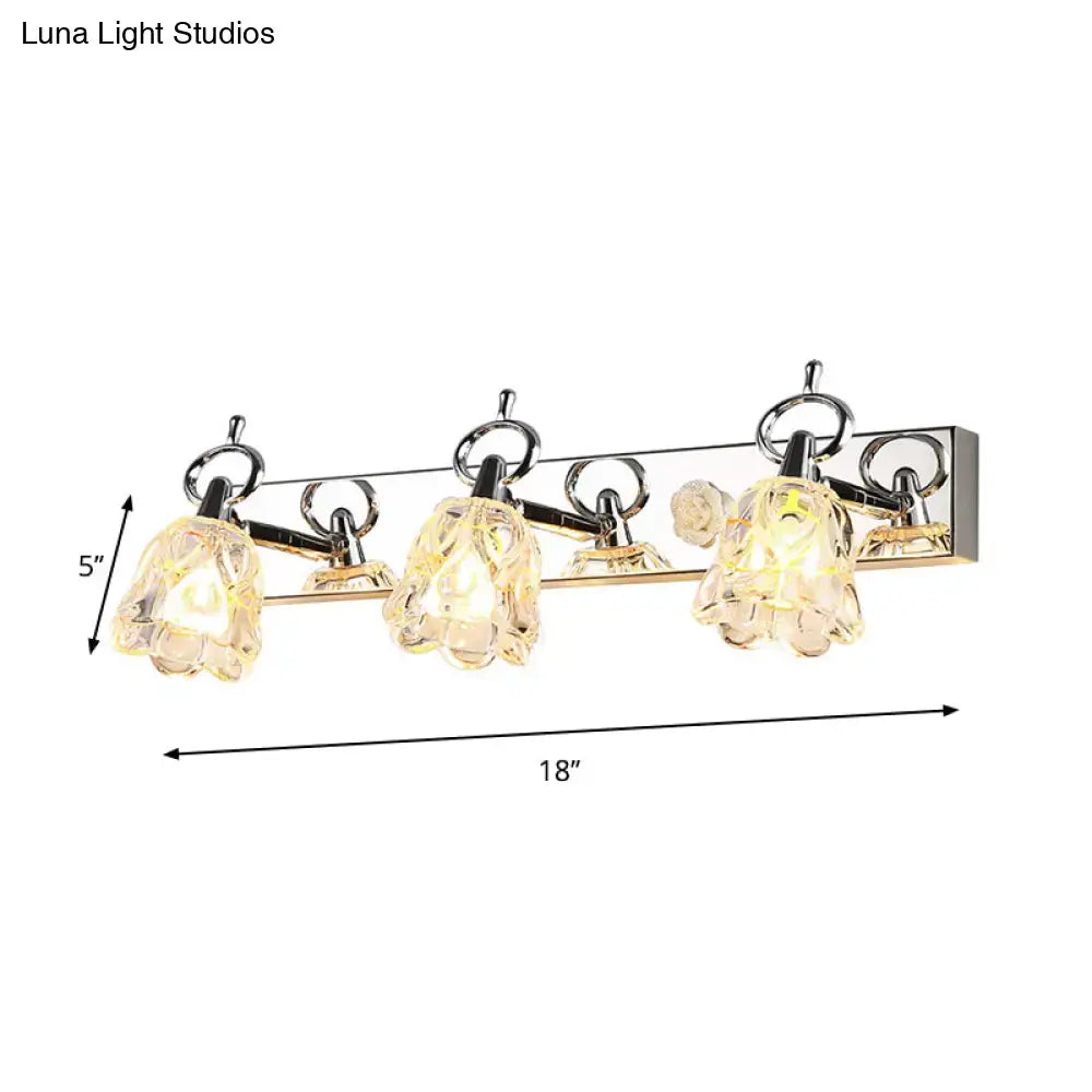 Modern silver finish wall light with four clear glass flower-shaped shades for bathroom vanity lighting