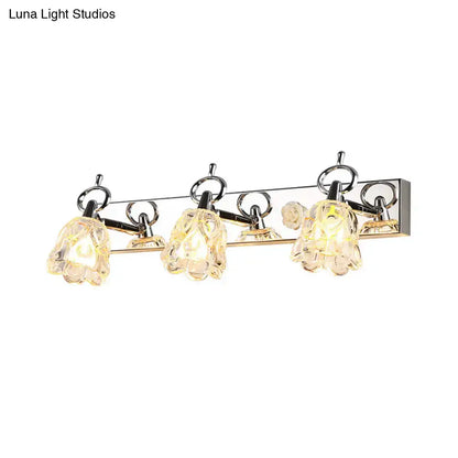 Modern silver finish wall light with three clear glass flower-shaped shades for bathroom vanity lighting