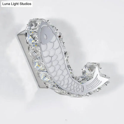 Modern silver fish wall sconce featuring a crystal block shade with clear crystals for bedroom lighting