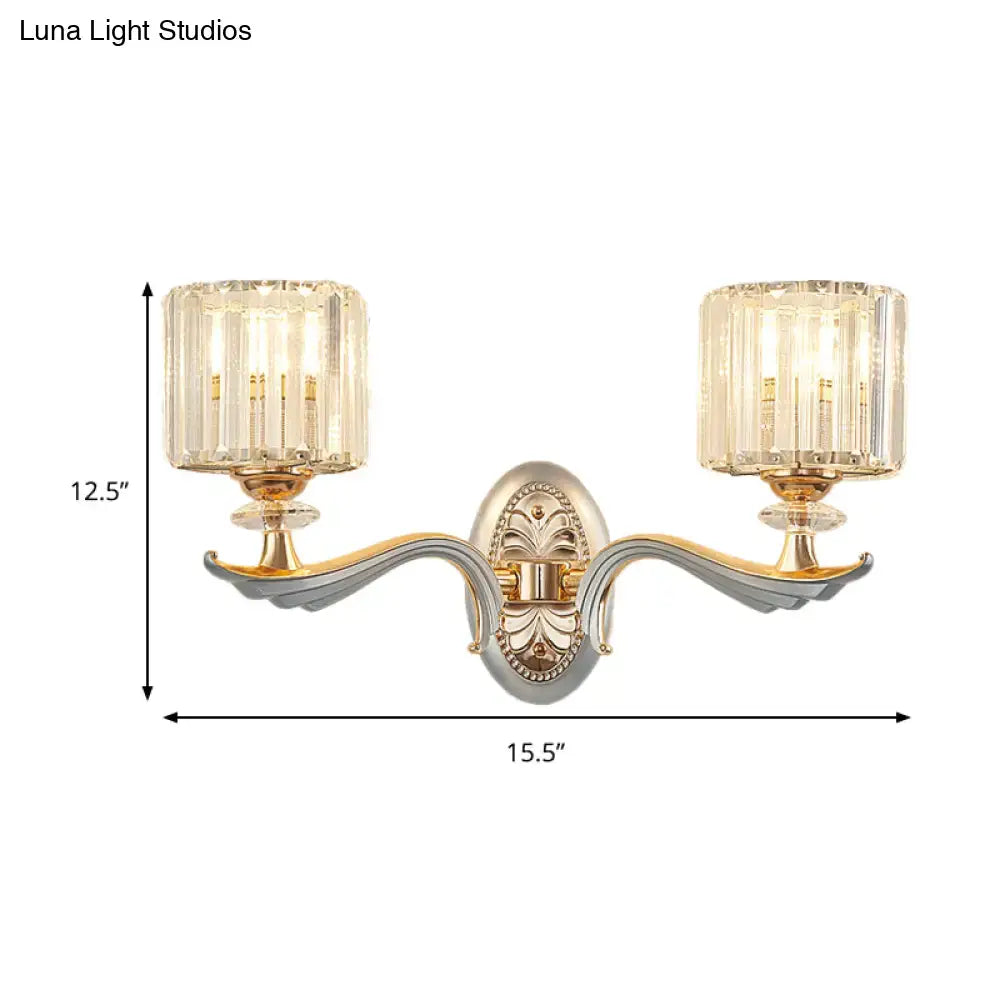 Elegant two-light flush mount wall sconce with gold and silver-toned arms, clear crystal shade, and bulb base details