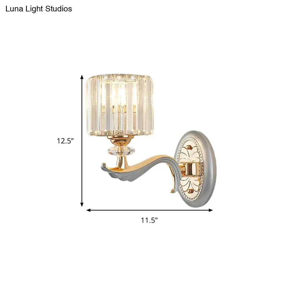Elegant gold-toned flush mount wall sconce with clear crystal shade and ornate decorative backplate featuring bulb base