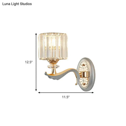 Elegant gold-toned flush mount wall sconce with clear crystal shade and ornate decorative backplate featuring bulb base