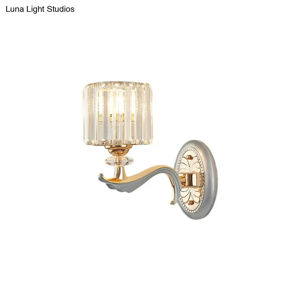 Elegant modern silver flush mount wall light with clear crystal shade and gold-toned metal arm on ornate silver backplate