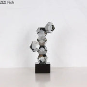 A sleek modern silver geometric crystal ball desk ornament sculpture with interconnected faceted spheres on black base