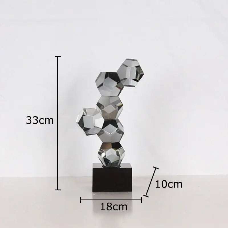 A sleek 33cm tall modern silver geometric crystal ball desk ornament with interlocking facets on a black base