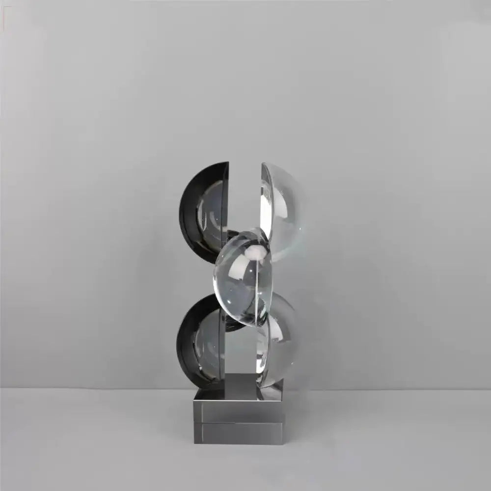 Modern silver geometric crystal sculpture with interlocking transparent and black spheres on a metallic base for home decor