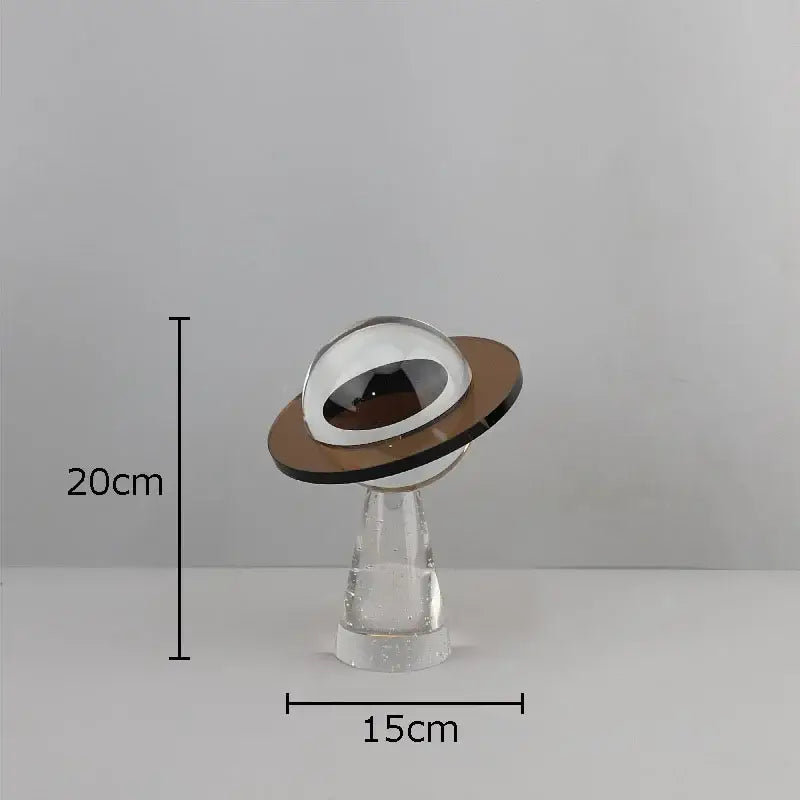 A sleek transparent glass desk sculpture with a reflective silver dome and brown base for modern decorbites geometric crystal star decor