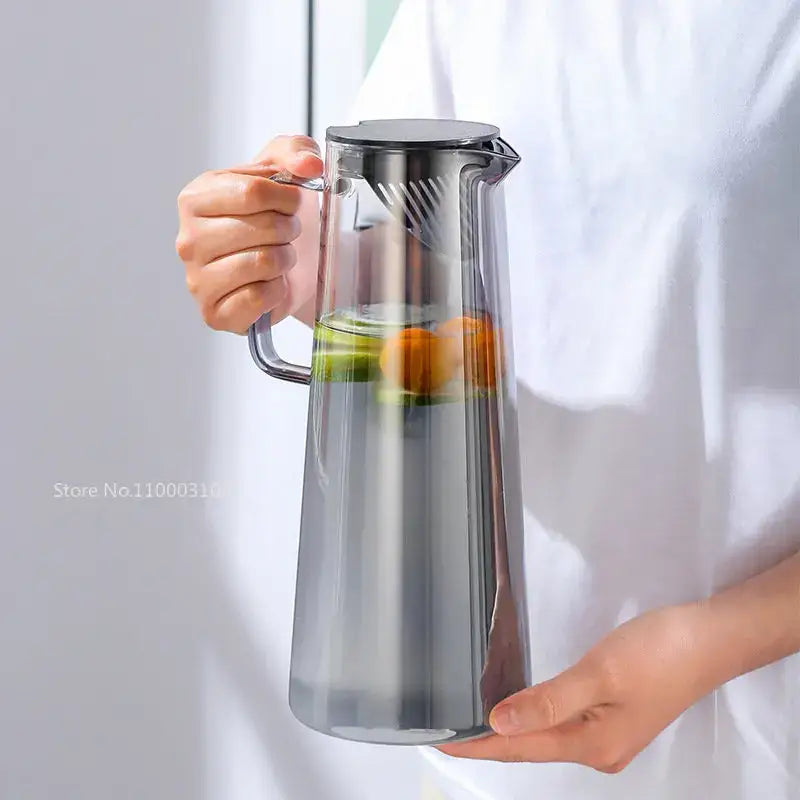Modern silver glass water pitcher with sleek stainless steel lid handle and integrated strainer for infused water
