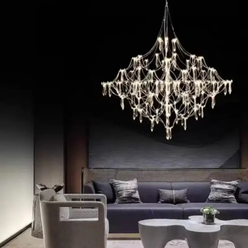 A modern silver and gold pendant light with metallic frame and crystal elements serving as a dining room focal point