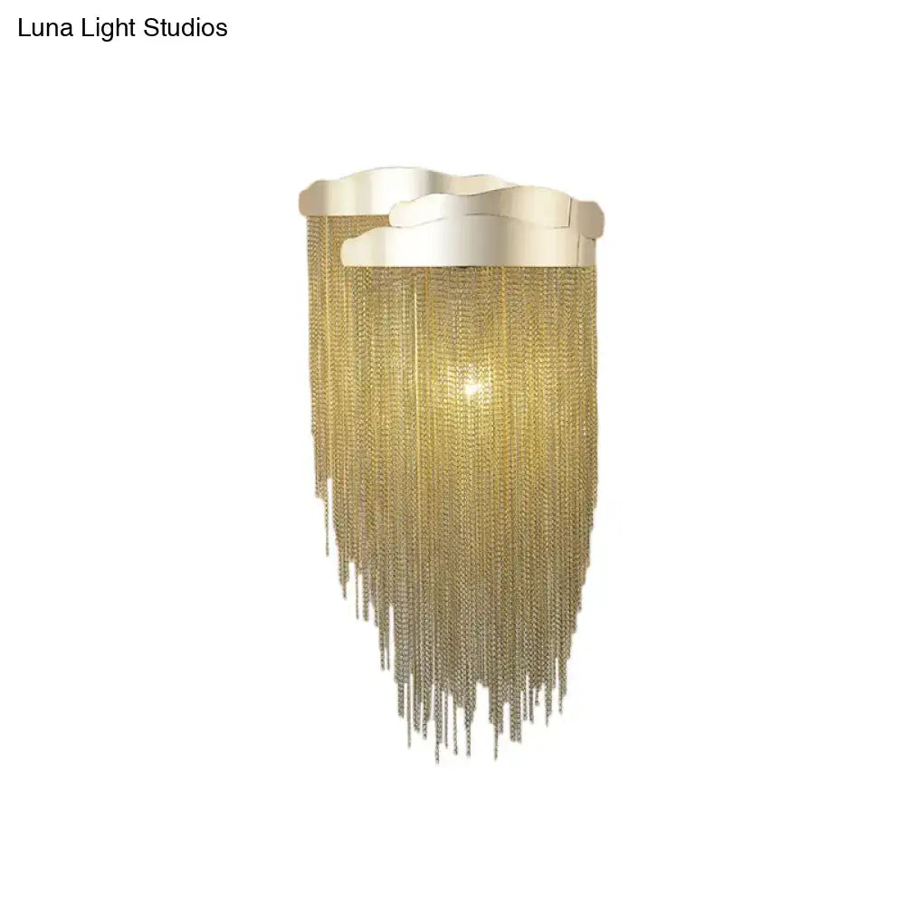 Modern silver and gold tassel design wall lamp with gold-toned chain fringe and wave-shaped metallic top bulb base