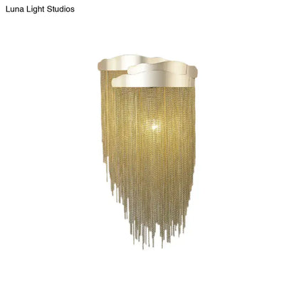 Modern silver and gold tassel design wall lamp with gold-toned chain fringe and wave-shaped metallic top bulb base