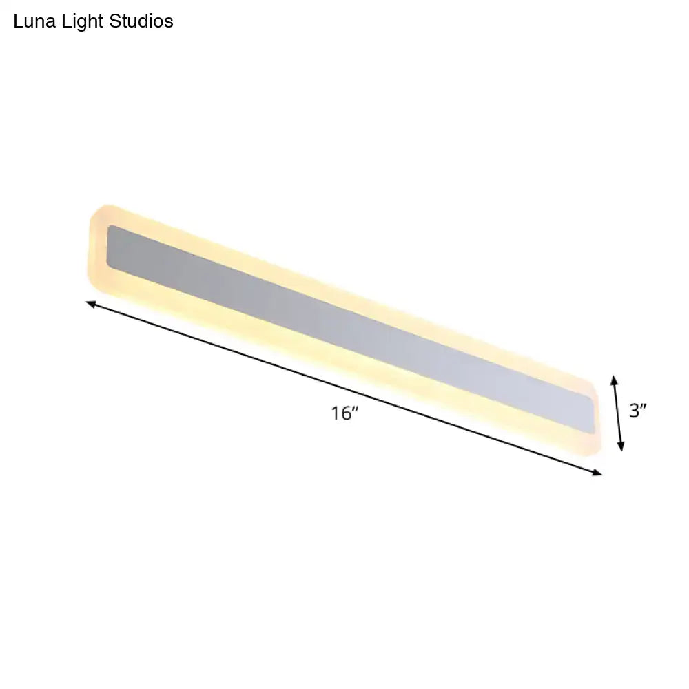 Modern silver led wall light with elongated metal shade featuring a 16-inch slim led light emitting warm yellow glow