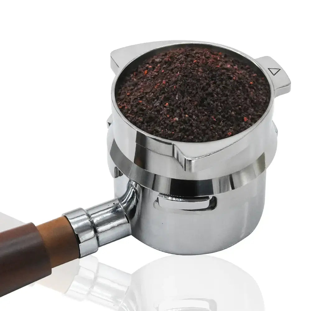 Modern silver machined stainless steel dosing funnel ring with wooden handle filled with dark ground coffee in portafilter