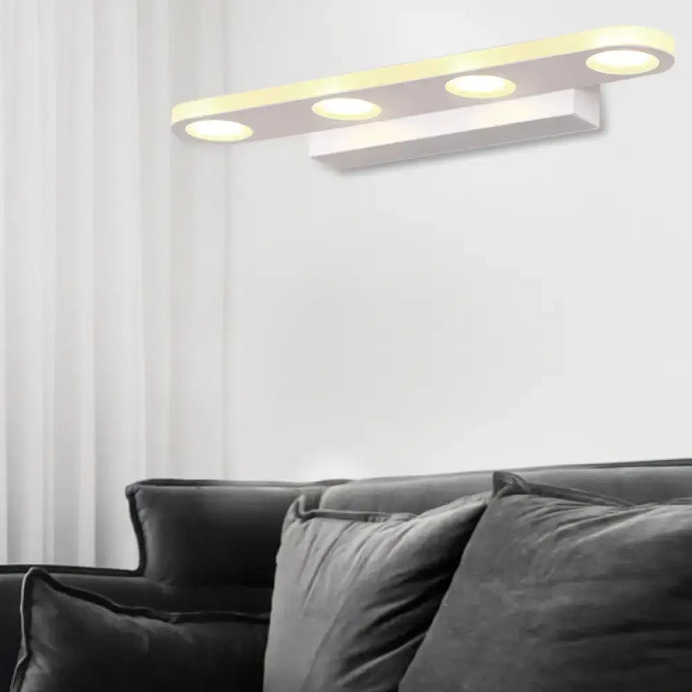 Modern silver oblong acrylic led bathroom vanity wall light with three circular warm white led bulbs mounted on white wall