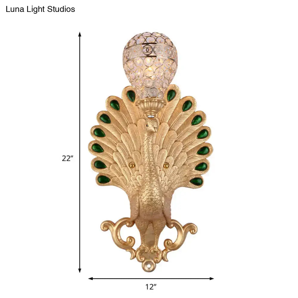 Gold-toned golden peacock wall light with green gemstone eyes and crystal globe top for bedroom sconce lighting
