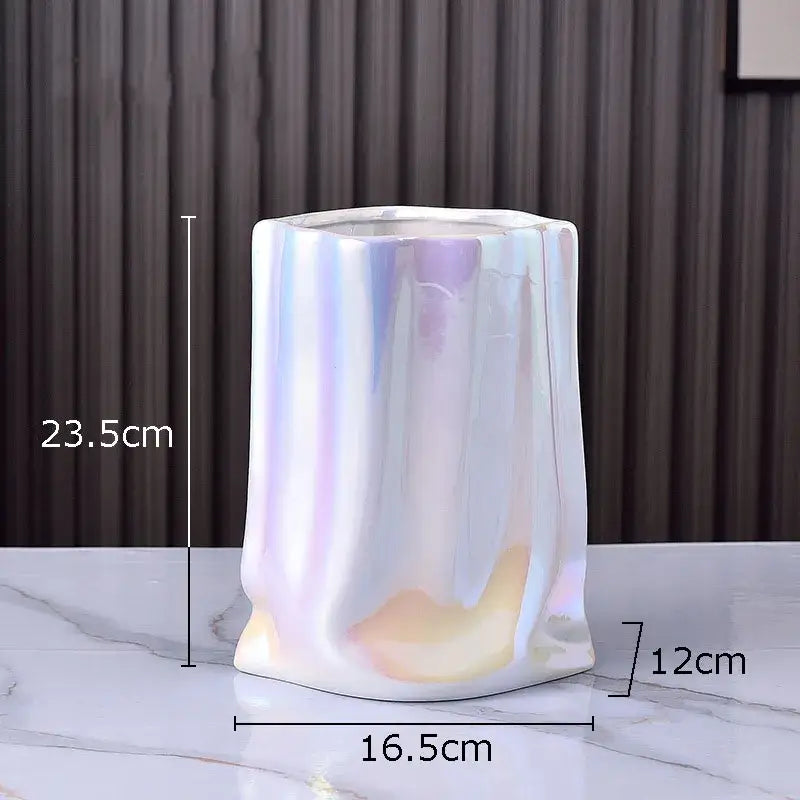 A glossy iridescent pink ceramic vase with a modern rectangular shape featuring pleated texture for living room decor