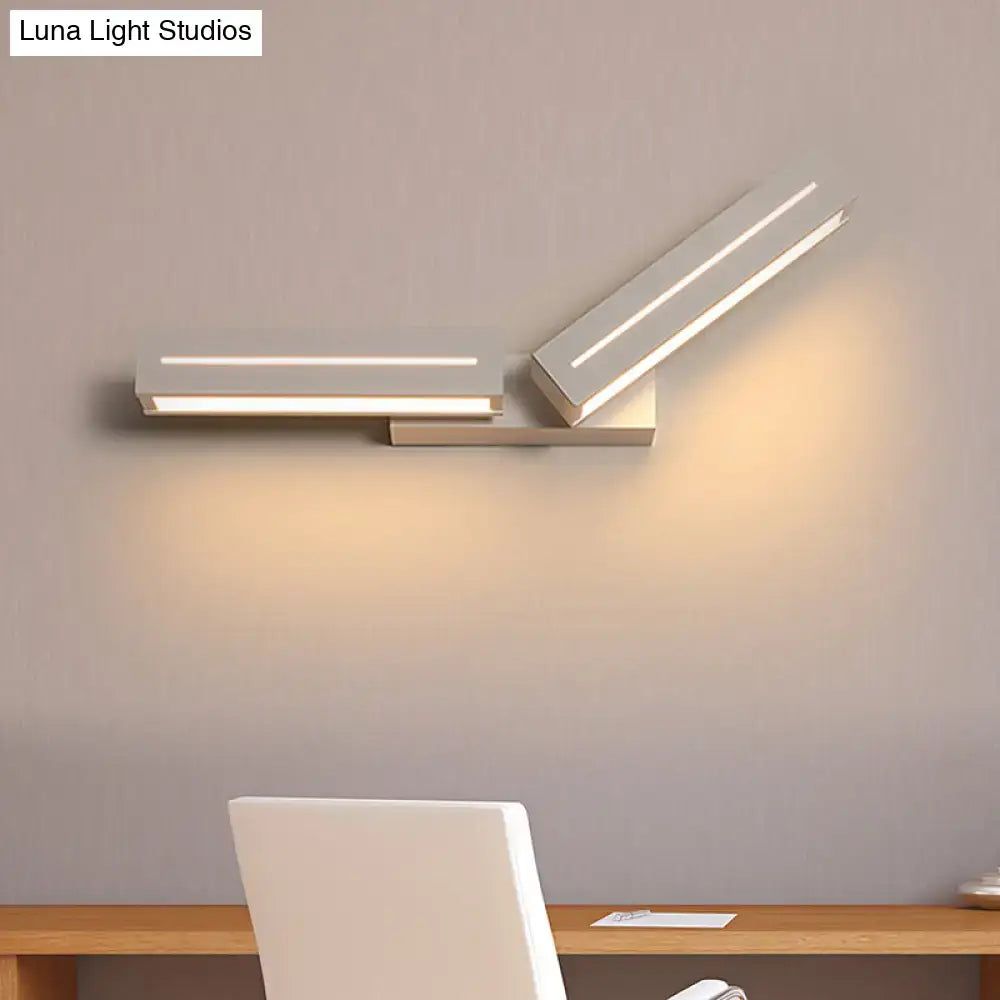 Modern silver rectangular wall mounted light with sleek angular design and two illuminated white led panels for bedroom use