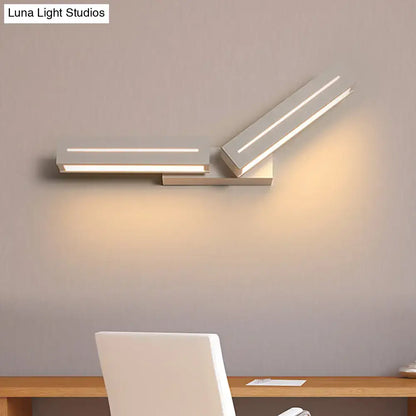 Modern silver rectangular wall mounted light with sleek angular design and two illuminated white led panels for bedroom use