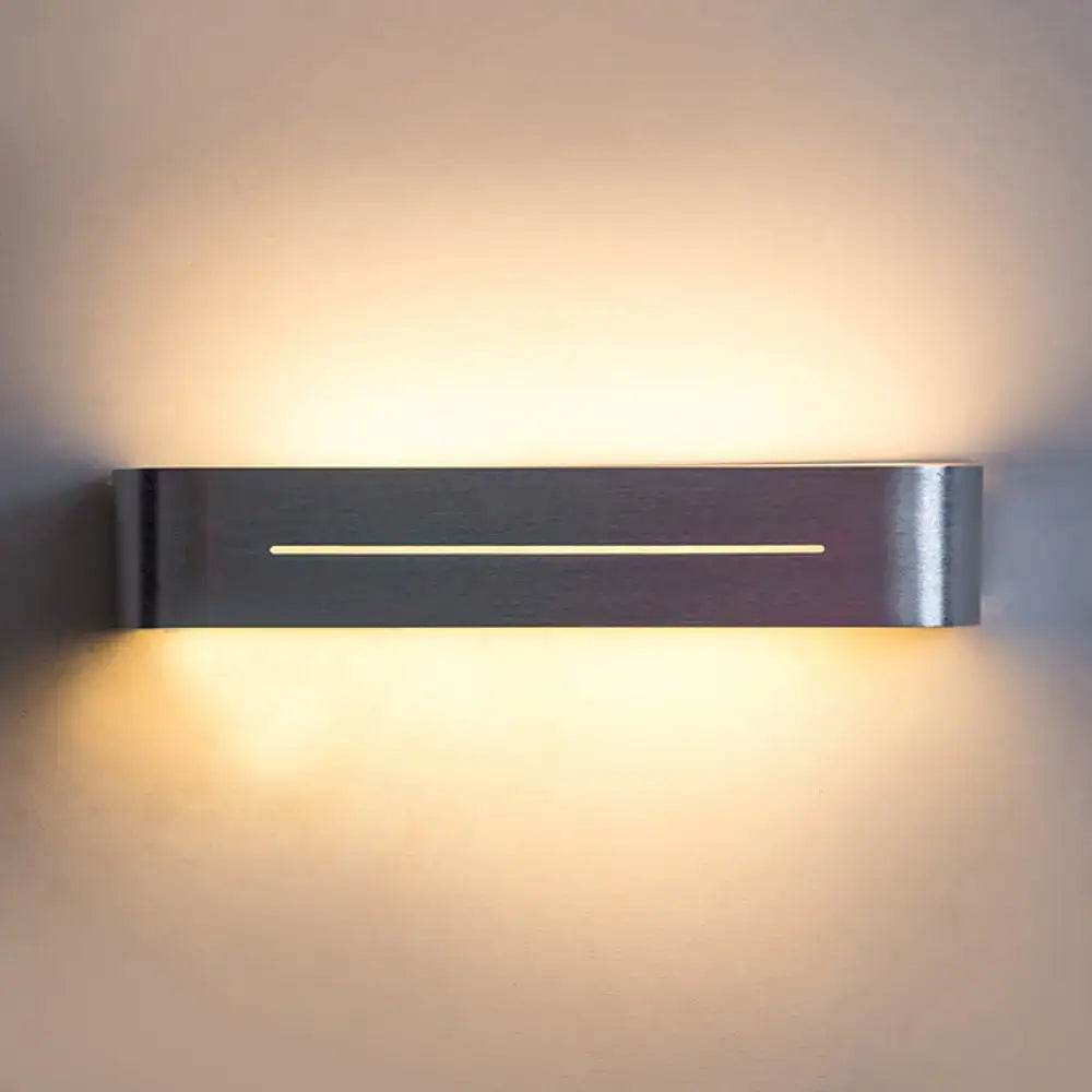 Modern silver rectangular led wall sconce with aluminum shade and brushed stainless steel finish providing warm ambient lighting