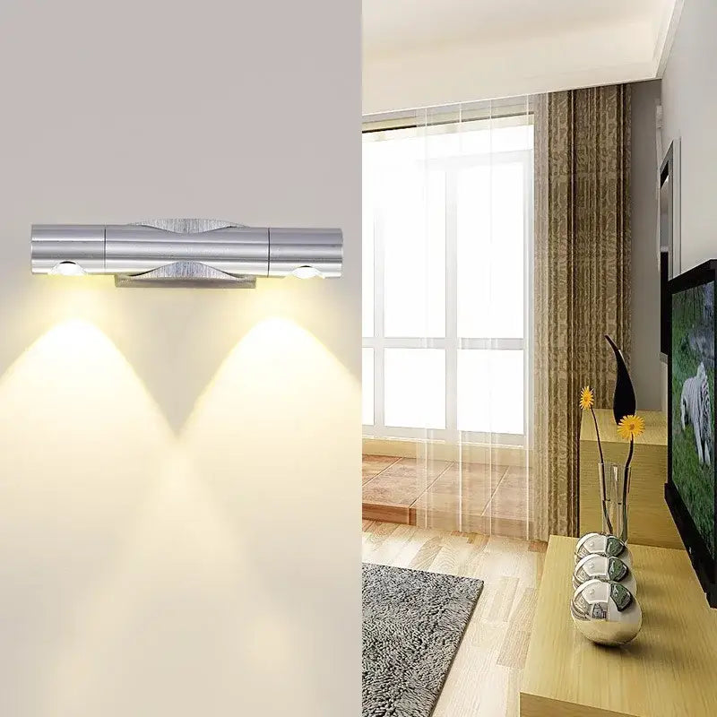 Modern silver metallic rotatable wall lamp with dual adjustable spotlights casting warm light for bedroom decorbites wall lamp