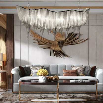 A modern silver tassel chain chandelier with translucent glass fringe and metallic frame hanging in dining room decorbites gold tassel