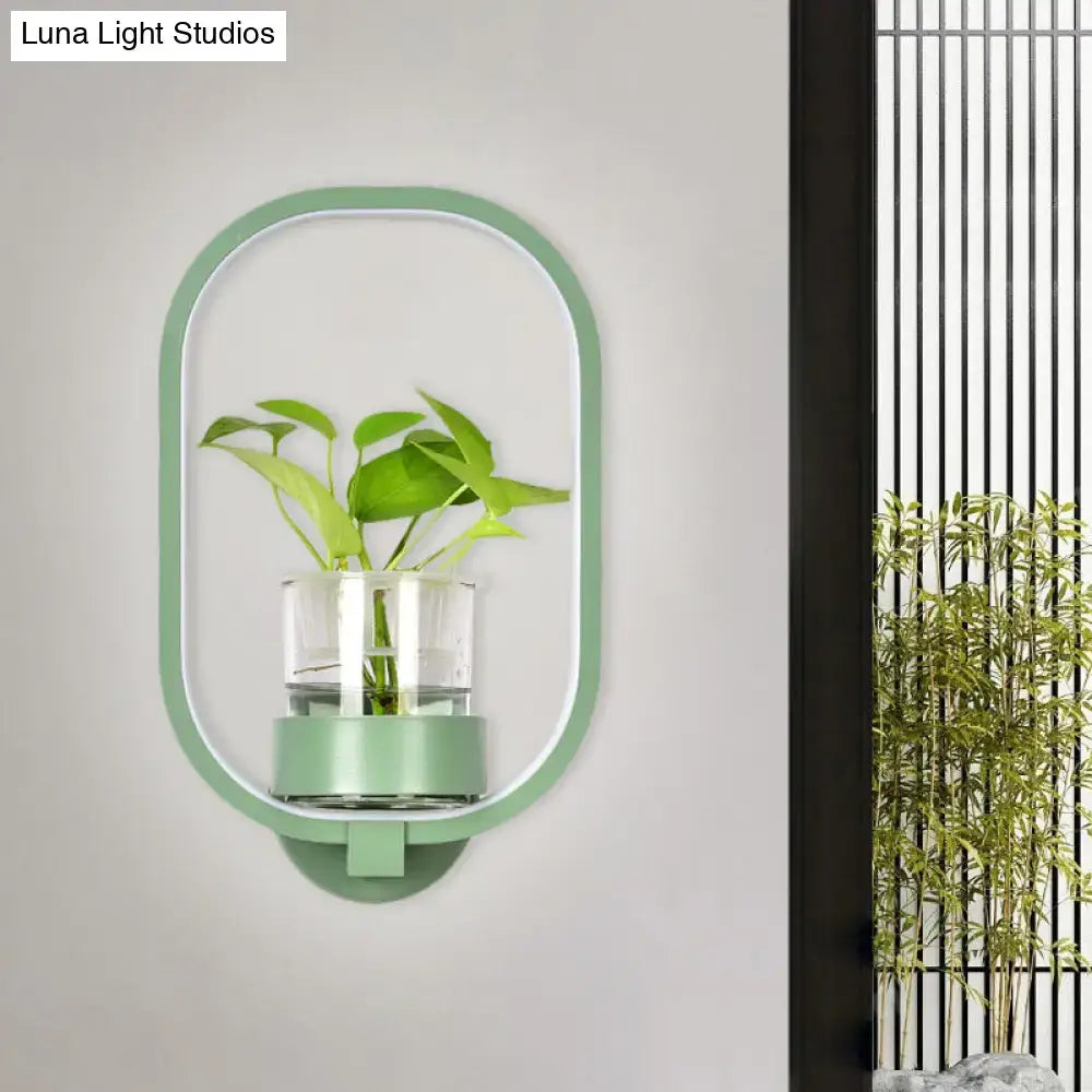Modern silver wall light with a mint green oval wall-mounted plant pot and clear glass container for 110v-120v use